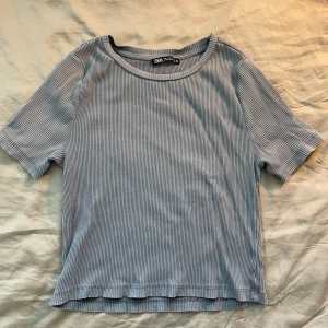 Randig topp från Zara - Säljer en snygg, randig topp från Zara . Den är kortärmad och har en rund halsringning. Perfekt för en avslappnad look eller som ett basplagg i garderoben. Toppen är i bra skick och passar till både jeans och kjol.