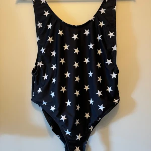 Svart baddräkt med stjärnor - Säljer en superfin svart baddräkt med vita stjärnor över hela tyget. Den är helt ny och från missguided. 
