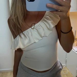 Topp med volang  - Superfin oneshoulder topp från hm. I fint skick 