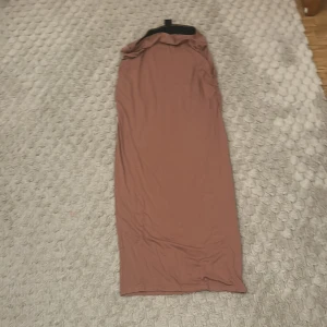 Rosa lång kjol från Gina Tricot - Säljer en stilren rosa kjol  från Gina Tricot. Kjolen har en enkel design och är perfekt för en avslappnad look. Den är tillverkad i ett mjukt material som ger en bekväm passform.