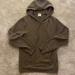Brun kashmir hoodie från John Henric - Säljer en lyxig brun hoodie i 100% kashmir från John Henric. Den har en klassisk design med huva och dragsko samt en praktisk magficka. Perfekt för en stilren och bekväm look. Bra skick inga defekter