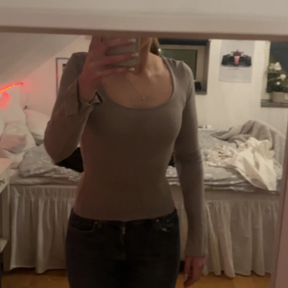 Säljer en stilren beige långärmad topp med rund halsringning. Toppen har en tight passform och är perfekt för en enkel och elegant look. Materialet ser mjukt och bekvämt ut. (Man ser färgen tydligare på sista bilden då de va dåligt ljus på de andra). Yläosat.