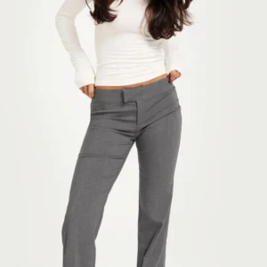 Grå kostymbyxor - Snygga grå kostymbyxor med en stilren design. Byxorna har en rak passform och är perfekta för en elegant look. Aldrig använda, köpta på Nelly för 400kr. Kan tänka mig lägre pris
