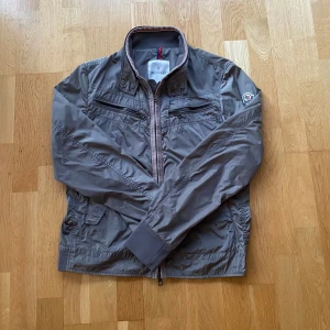 Moncler field jacket - En moncler jacka i storlek S passar mellan 175-185 cm och är i bra skick. Jag bytte jackan på Plick och han hade köpt den på secuiro fashion och jag fick den sista bilden av honom så jag antar att jackan är äkta. Kom med bud och frågor. Vill bli av med den.