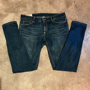 Mörkblå jeans från Dondup - Skick: 8/10, liten slitning vid ena skärp ögglan - Storlek: 29 - Längd:98cm Midja:41cm ben:14cm - Nypris: 2000kr+