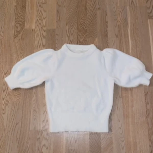 Vit tröja från H&M storlek S nästan aldrig använd (Swish) - Säljer en stilren vit tröja från H&M med puffiga trekvartsärmar. Perfekt för en elegant och avslappnad look. Tröjan är mjuk och bekväm, idealisk för både vardag och speciella tillfällen.