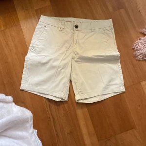 Beige shorts från L.O.G.G. - Snygga beige shorts från L.O.G.G. med knappdetaljer och fickor både fram och bak. Perfekta för en avslappnad stil under varma dagar. Tillverkade i ett bekvämt material som passar bra till sommarens alla äventyr.