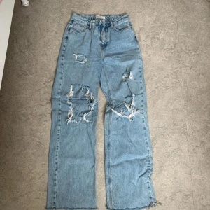 Ljusa jeans med slitningar från Primark strl 38 - Säljer ett par ljusa jeans från Primark med coola slitningar och en avslappnad passform. De har en knappgylf. Perfekta för en trendig och avslappnad stil.