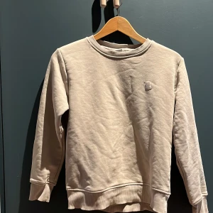Beige tröja från Grunt - Lite nopprig på framsidan men det går säkert att ta bort. Barnstorlek M, ca 146/152