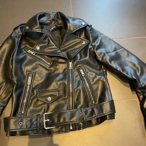 Fakeskinn jacka Zara - Säljer en skitsnygg skinnjacka från Zara. Aldrig använd. Det är fakeakinn och nyköpt kostar den 699. 