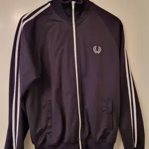 Svart Fred Perry tracktop. Tillverkad i Portugal. Rekommenderas!