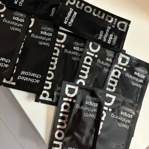 Säljer flera förpackningar av Diamond Activated Charcoal Teeth Whitening Strips. Dessa strips är designade för att ge dig ett vitare leende med hjälp av aktivt kol. Perfekt för att fräscha upp tänderna och få bort missfärgningar. Ger snabbt resultat!