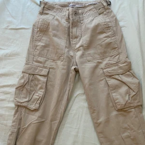 Beigea, raka, cargo byxor - bershka, xs/32 - Säljer dessa Cargo byxor köpta på berskha. Bra skick! Storlek 32/xs Skriv privat för bilder med plagget på!