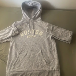 Grå SOC hoodie med vit text i mitten. - Detta är en grå hoodie från SOC med en vit text i mitten. Hoodien är i storlek M för barn.