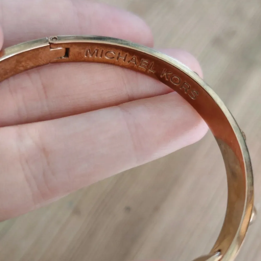 Ett gulsig armband med nitar och fint spänne från Michael Kors, lite slitage där av priset, dock inget som märks. Accessoarer.