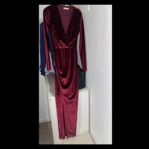 Finklänning  -  Klänning i nyskick från Nelly i stl XS  I färgen burgundy. (Mer mörkare än på bild blir ljusare i ljus men inte lika klar röd ser ännu finare ut i verkligheten enligt mig)   Klänningen har slits på höger sida se bild.   Hör av er vid intresse!  Mvh
