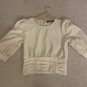 Intressekoll blus - Jättefin creme vi/beige blus som sitter tajt i midjan med puffiga armar