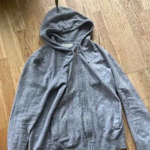 Grå Cashmir Hoodie Zip - Väldigt eftertraktad zip hoodie 100% cashmir, säljs pga har 2 andra av samma färg passar både s/m