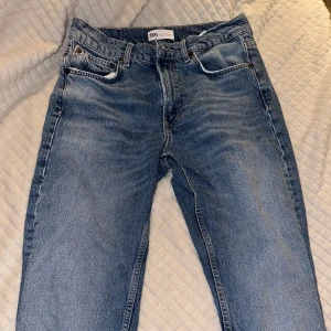 Blå jeans med hög midja - Säljer ett par klassiska blå jeans med hög midja. De har en straight passform och är perfekta för både vardag och fest. Jeansen har en dragkedja och knappar framtill samt fickor både fram och bak. De är i bra skick och redo för en ny ägare!
