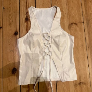 Väst i läder med knytdetalj - Handgjord väst i läder med snygg knytdetalj framtill från Barcelona   Nyskick