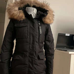 Hollies jacka  - Hollies vinterjacka i perfekt skick, endast använd en vinter. Kostar ca 5000kr ny men säljer för 700 för vill ha den såld. Man kan spänna åt i midjan så passformen kan vara hur  man vill. Storlek 34. Äkta päls 