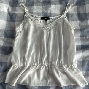 Vit top  - En vit top från bikbok fin lite trasig i under sidan av tröjan 