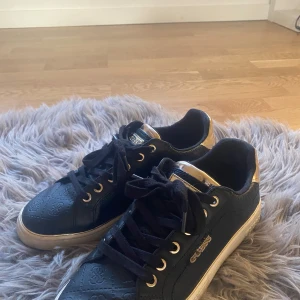 Guess skor  - Säljer dessa svart, guldiga Guess skor i storlek 39 för ett bra pris. Har kommit till användning men är som nya. Priset när jag köpte dem var 1300 och jag säljer skorna för 800, priset kan diskuteras. Intresserad? skriv gärna på instagram, epus1c 