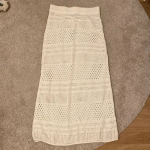Vit stickad kjol från BikBok - Säljer en superfin vit stickad långkjol från BikBok i storlek XS. Kjolen har ett snyggt hålmönster som ger en luftig och somrig känsla. Perfekt för varma dagar eller som en stilren detalj till din outfit. Passar både till vardags och festliga tillfällen! Nypris ca 500kr🤍