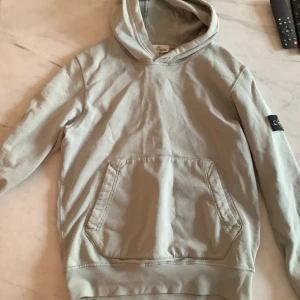 Stone island hoodie - Säljer nu denna extremt snygga Stone island hoodie för endast 450 kr den säljes för att den är för liten för mig. Passar perfekt till ett par ljusblå jeans och funkar jättebra nu till vintern. Storleken är S och hoodien köptes på ni för ett år sedan.