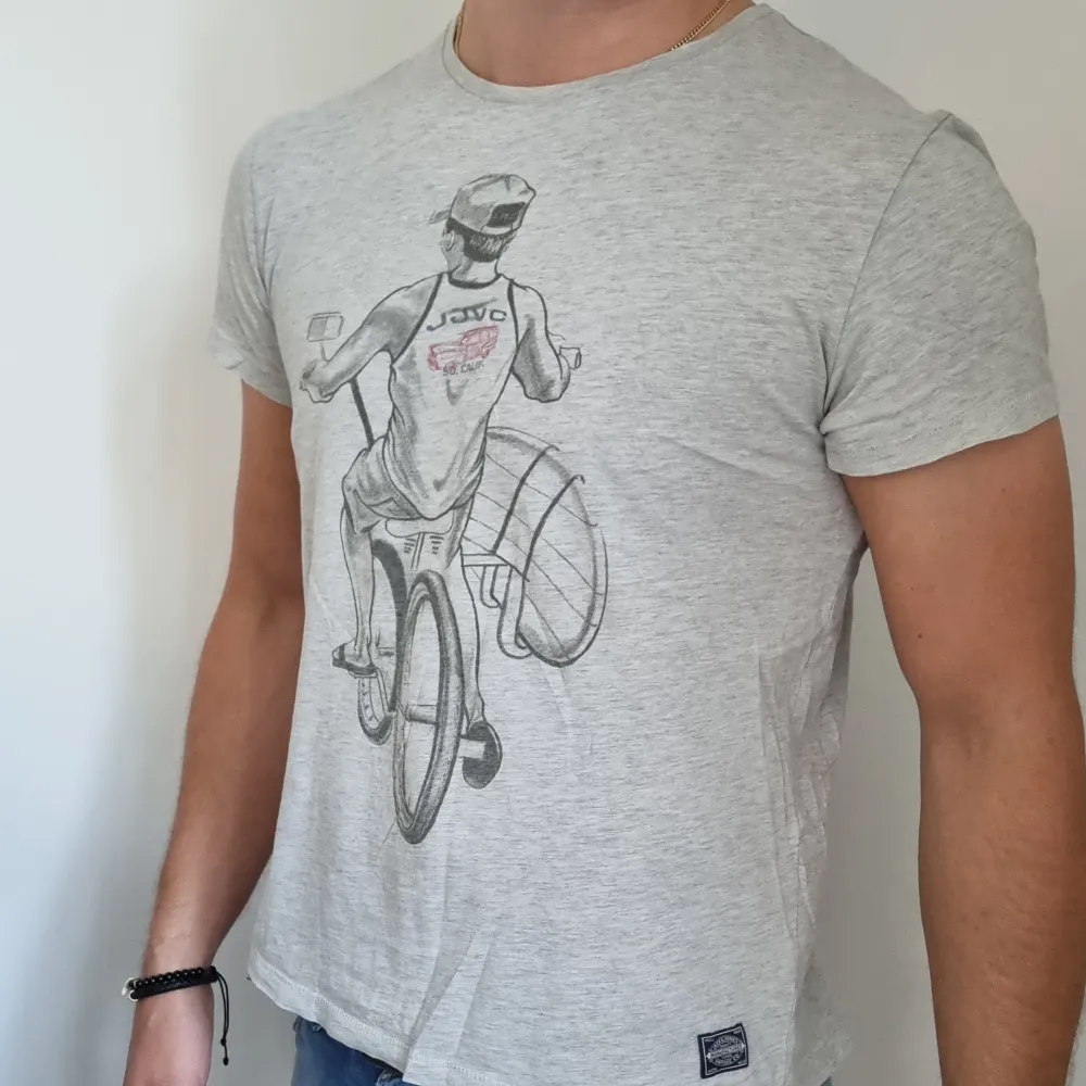 Grå T-shirt med ett snyggt tryck av 100% bomull, från Jack & Jones. Något mindre än en traditionell stl. L. Fint skick och skönt material. . T-paidat.