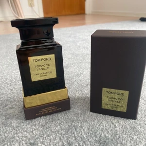 Tom Ford Tobacco Vanille Eau de Parfum - Säljer en lyxig Tom Ford Tobacco Vanille Eau de Parfum. Flaskan är elegant och svart med en guldig etikett och detaljer. Den innehåller 100 ml av denna ikoniska doft som kombinerar rika noter av tobak och vanilj. Bara testad 98% kvar!