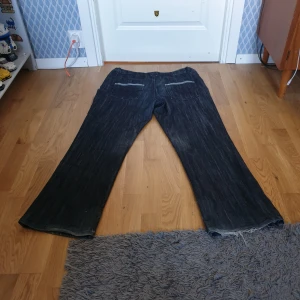 Svarta baggy y2k jeans - Baggy jeans med väldigt nice detaljer på bakfickorna. Ungefär 48 cm breda i midja och 108 cm långa