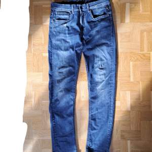 Säljer dessa blåa Replay jeans. En slimmad modell liknande anbass i storlek 30/34. Design med en liten reva precis under höger framficka. Lite slitna i rumpan. Skriv vid fler frågor.