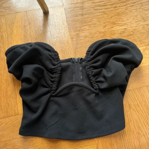 Svart topp Gina tricot - Svart bandeautopp från Gina tricot. Använd 1 gång så den är i fint skick. Perfekt till fest
