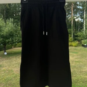 Svart midikjol i ”mjukis-tyg” - Svart mjukis-kjol från H&M i storlek XS. Säljer den pga att den är lite för liten för mig som normalt har S-M i underdelar. Fint skick 💞 Stretchig!!  (ALDRIG ANVÄND)  Längd: 72 cm Midja: 64 cm