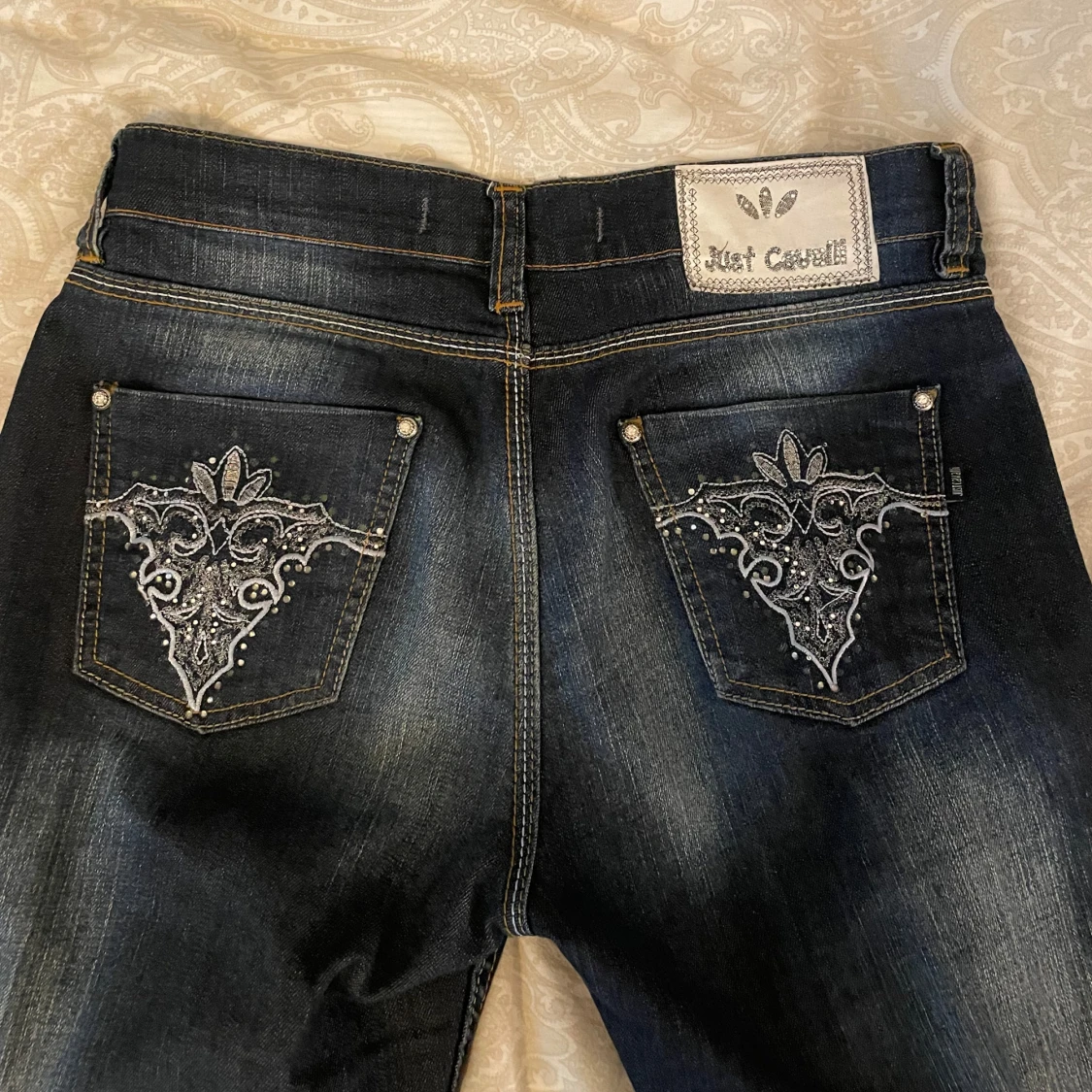 Mörkblå jeans med broderade bakfickor