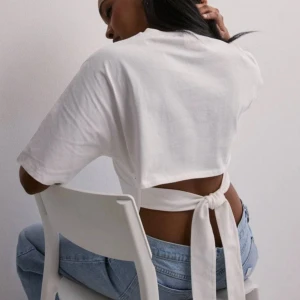 Vit T-shirt Nelly🤍 - Säljer min vita T-shirt med öppenrygg och knytning från Nelly🤍Knappt andvänd