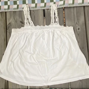 vit GAP linne med spets - En jättegullig GAP tröja i storlek 1 regular.  Tröjan är i kids storlek men rätt stor ändå. Den är i använt skick men finns inga fläckar eller hål. Skriv till mig för mer information, mått osv☺️ 