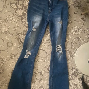 Jeans - Utsvängda högmidjade jeans som är jätte fina. Dom har hål på sig enligt designen och är i storlek petite s. Jag är 160 cm och dom passar perfekt. Dom släpar inte på marken eller något 