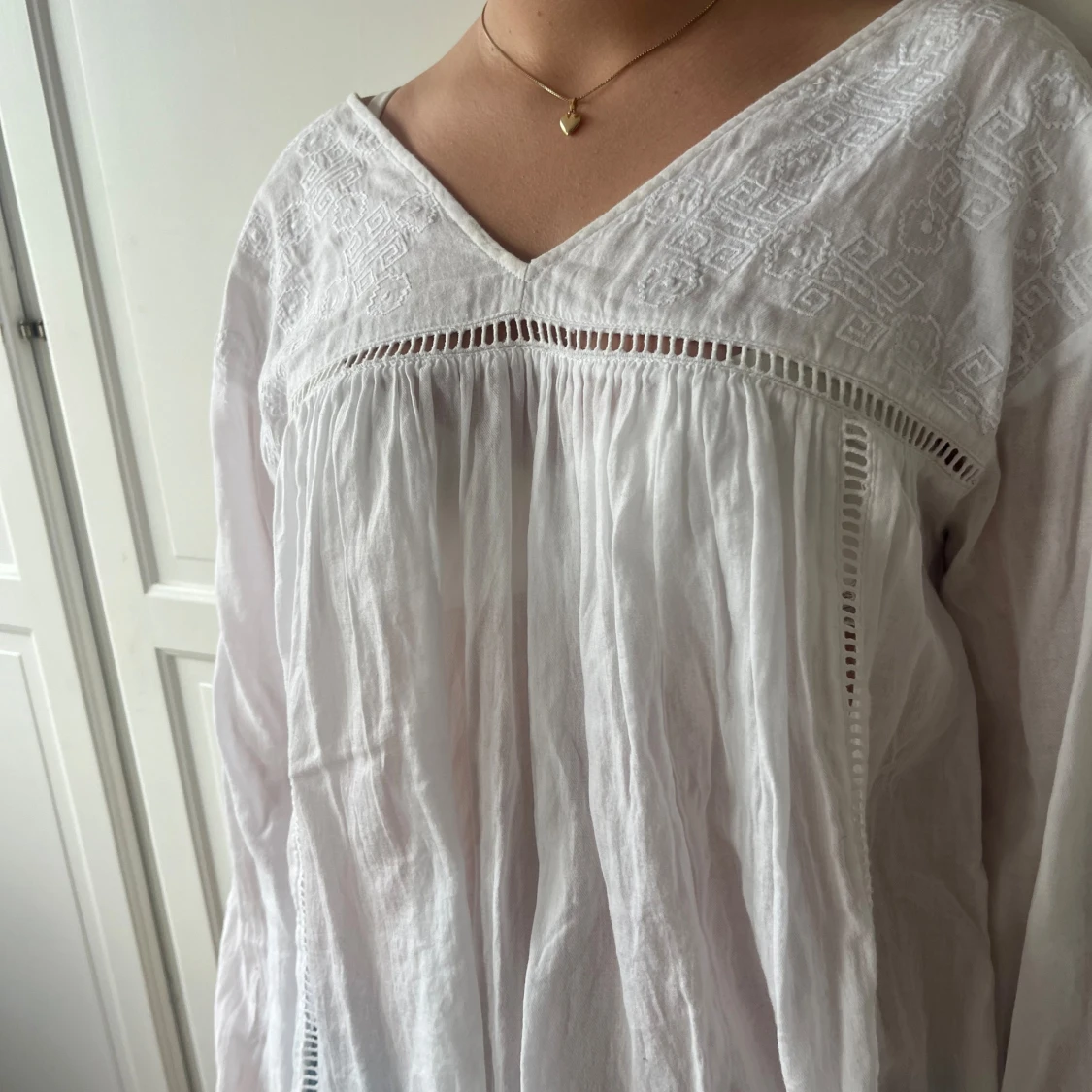 Vit sommrig blus med låg rygg och blomdetaljer - 1