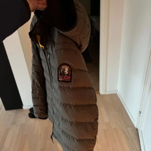 Brun dunjacka från Parajumpers - Säljer en snygg vinter jacka, mörk grön från Parajumpers. Jackan har en quiltad design och är perfekt för kalla dagar. Den har en dragkedja framtill och en mysig huva. Perfekt för vintern! Storlek L-M/Priset kan diskuteras vid snabb affär. Tveka inte