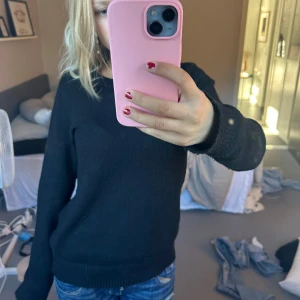 Svart stickad tröja - Säljer en klassisk svart stickad tröja som är perfekt för både höst och vinter. Den har långa ärmar och en normal passform, vilket gör den superbekväm och lätt att matcha med allt. Perfekt för mysiga dagar eller en stilren look. Lite nopprig 