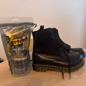 Dr. Martens Airwair - HELT NYA med tillhörande paket bestående av skoputsare med duk, 1 par svarta snören och 1 par gul/svarta snören  Dock utan låda pga skadad