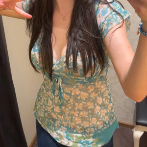 Babydoll top - A babydoll-style shirt inspired by the 21st century with a flower pattern and a small bow on the front. Even though the shirt is an XS size, I'm an S myself and it fits a smaller size as well as definitely an M size. The shirt is a chiffon/mesh style