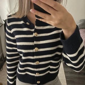 Randig Cardigan - Randig mörkblå/vit cardigan/kofta med guldiga knappar. Knappt använd. Super fin och stilren. Normal i storlek. Skriv för frågor! Pris kan diskuteras.