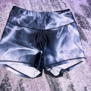 Säljer ett par snygga shorts från Anarchy Apparel i storlek L. De har ett coolt svart och vitt mönster som ser ut som rök eller dimma. Perfekta för träning eller en avslappnad dag. De är i bra skick och har en bekväm passform.