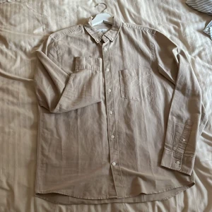 Beige skjorta i storlek M - En beige skjorta från H&M i storlek M Regular fit  Använd fåtal gånger  Väldigt bra färg som går att matcha till mycket, t.ex svart, grått och brunt.