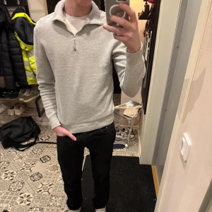 Ljusgrå stickad tröja med dragkedja - Säljer en stilren ljusgrå stickad tröja från east west. Finns inget att anmärka på tröjan utan i bra skick!         Är storlek M som sitter väldigt bra. Köp en schysst och populär tröja för en bra peng av mig!                                    Hör av dig vid frågor eller funderingar!👋