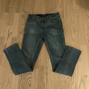 Blå jeansbyxor från Levis - Snygga blå jeansbyxor från Levis med klassisk femficksdesign och en bekväm passform. Perfekta för en avslappnad stil. De har en traditionell dragkedja och knappstängning.