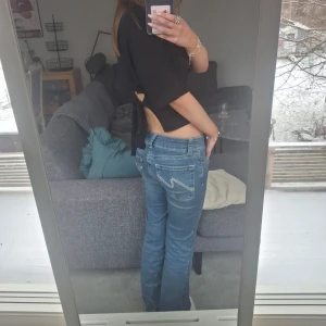 Mörkblå bootcut jeans från Nelly - Ett par mörkblå lågmidjade bootcut jeans från Nelly. Supergulliga fickor och trendiga jeans. På nellys hemsida kostar ett nytt par 699 kronor. Bra skick trots blivit använda en del.💞